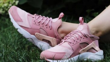 person wearing pair of pink lace up low top sneakers