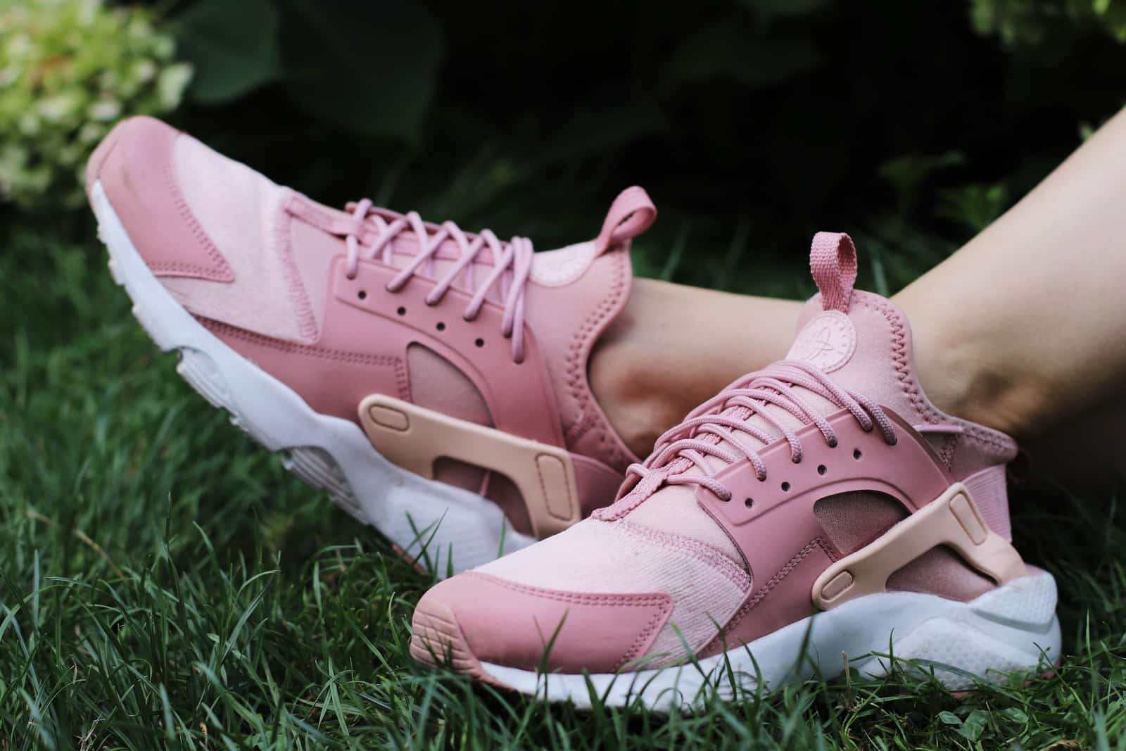 person wearing pair of pink lace up low top sneakers