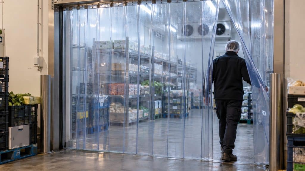 Cortinas de lamas PVC: 5 curiosidades sobre las que posiblemente desconozcas 3 Mano con guante mostrando la flexibilidad de una lama de PVC transparente